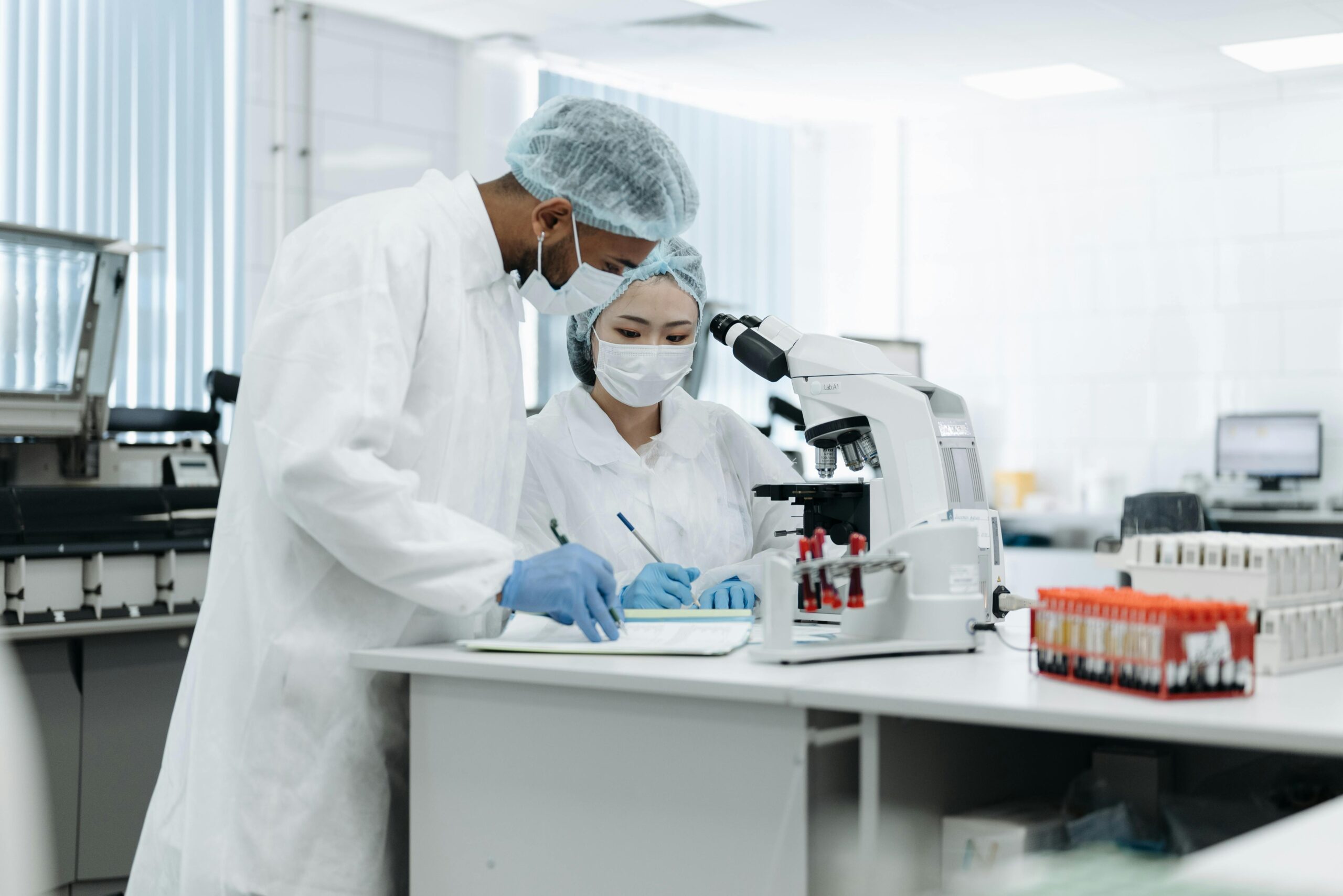 Two scientists in a laboratory conducting research with microscopes and lab equipment.